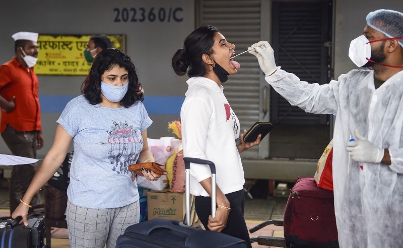 A health worker takes swab samples of a passenger for COVID-19 testing at Dadar railway station in Mumbai, Wednesday, Sept. 22, 2021. (PTI Photo/Kunal Patil)